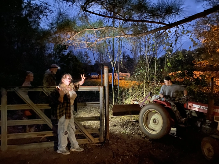 Four people landscaping with a tractor