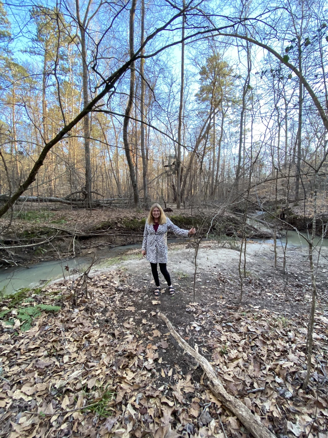 One person posing in front of a creek.