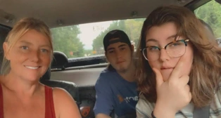 Three people posing in a car.