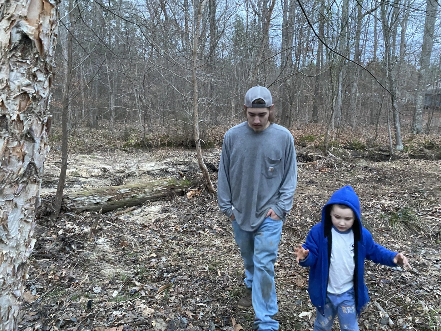 Two people walking a nature trail, one adult with a toddler.