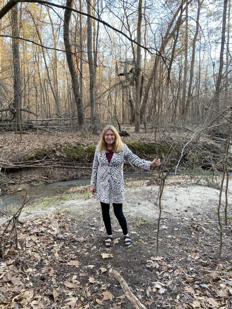 One person posing in front of a creek.