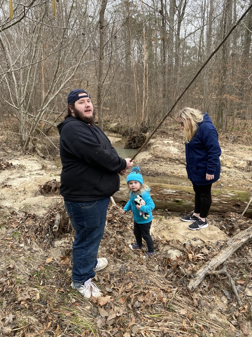 Two people posing in front of a toddler