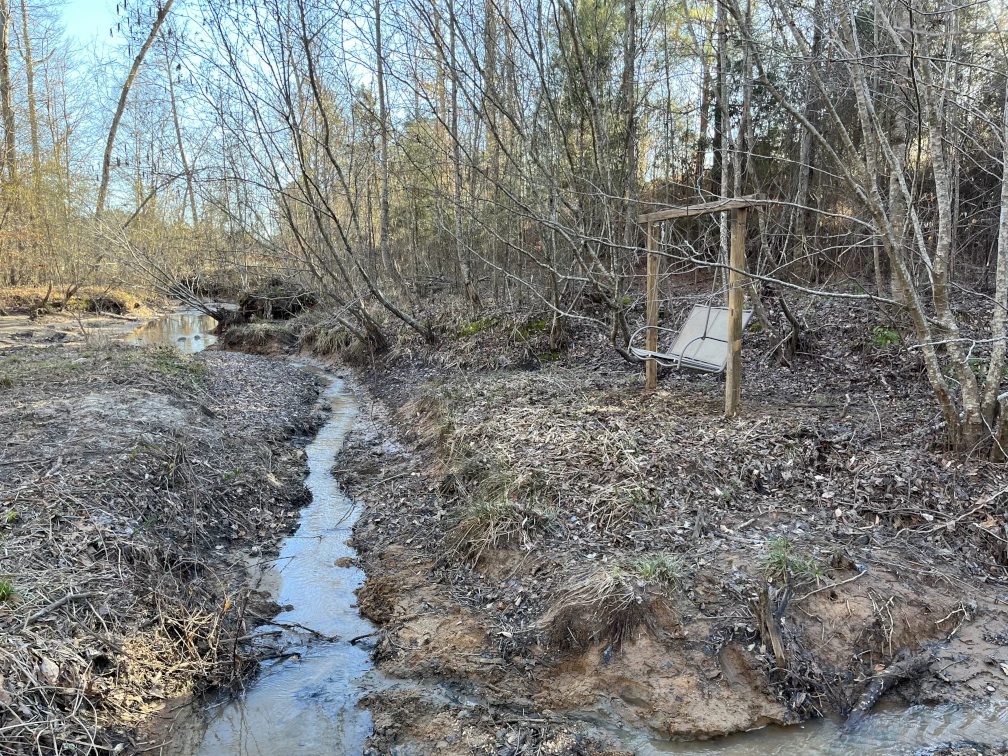 Creek in front of a swing in the woods