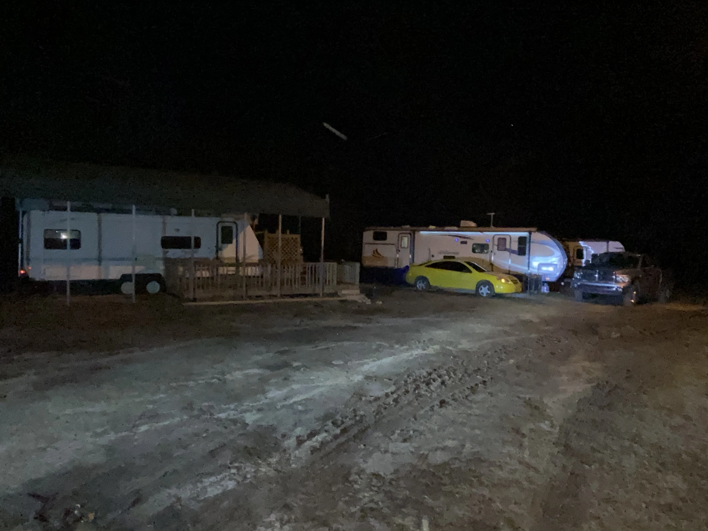 Campground at night with campers and cars