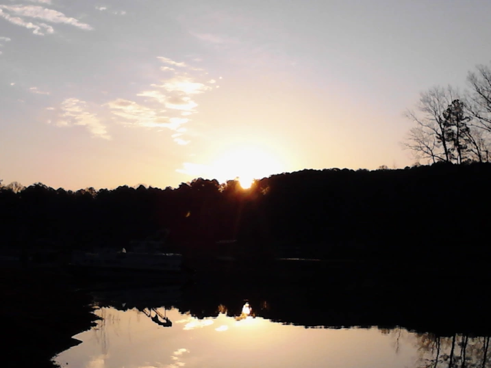 Sunset over the trees behind a lake